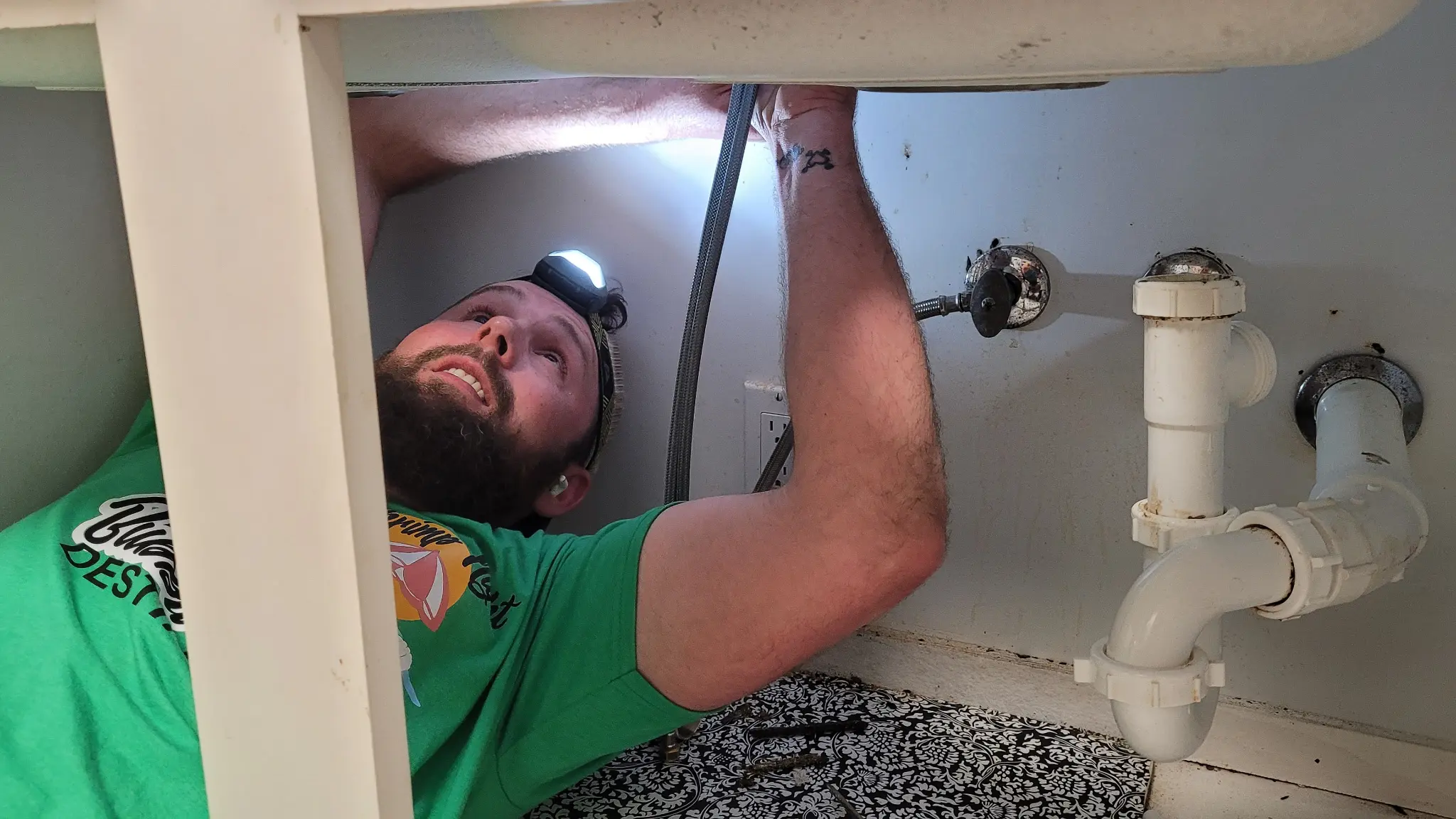Plumber working under sink